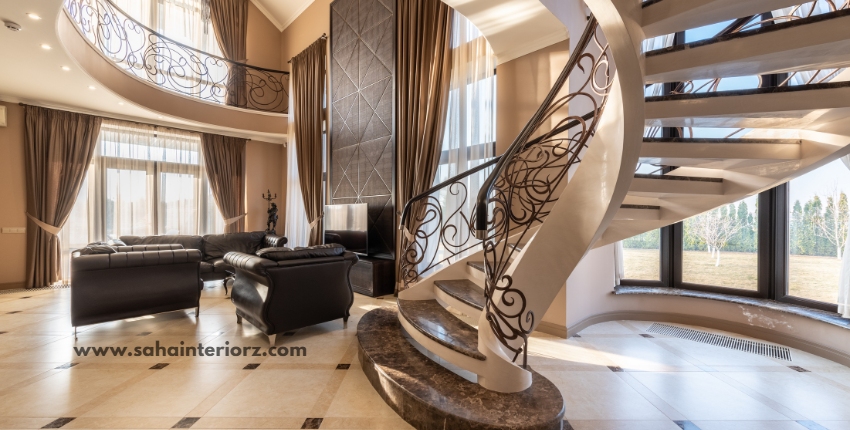 Luxury living room with a spiral staircase, black leather furniture, and natural lighting.