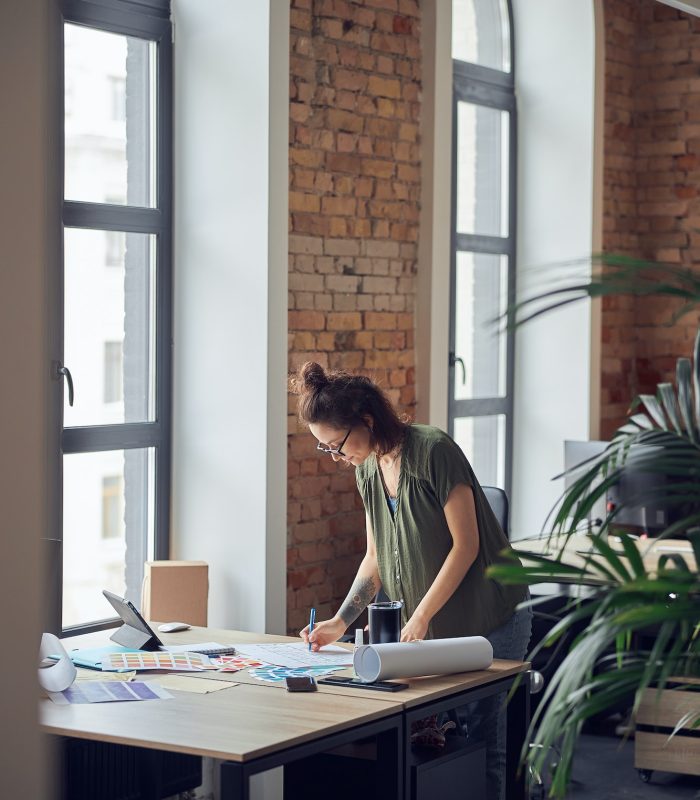 interior-designer-or-architect-in-casual-wear-with-messy-hairdo-looking-focused-while-working-on.jpg